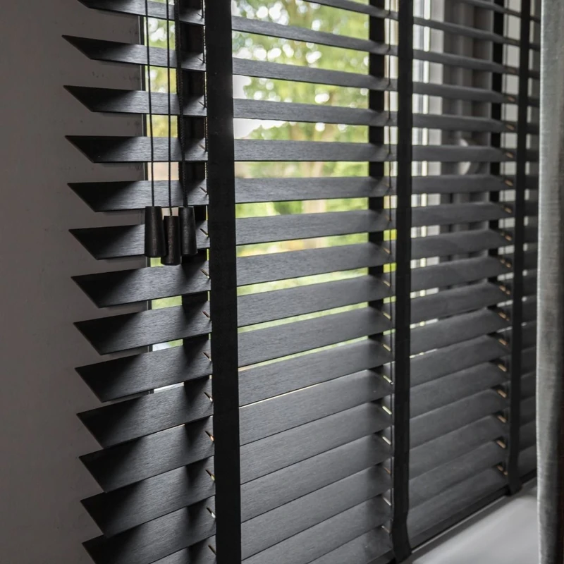 Close-up of dark wooden window blinds and cords.