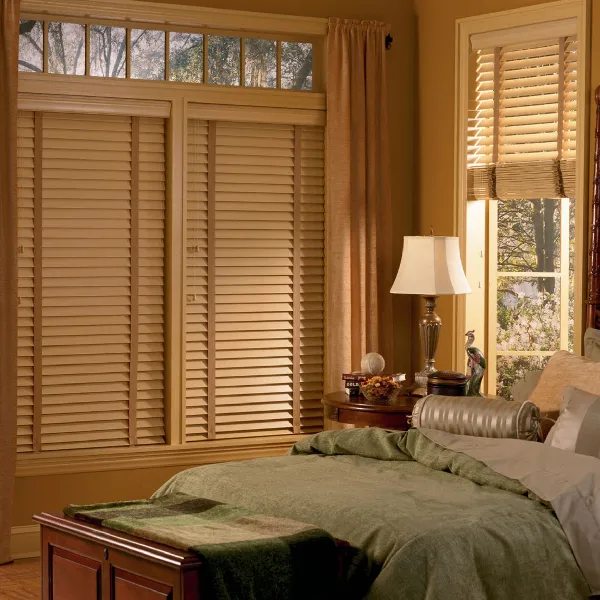Light wooden blinds in a cozy bedroom.
