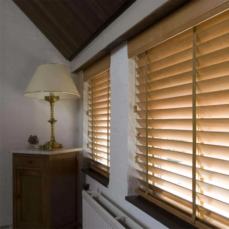 Light wooden blinds next to a vintage table lamp.