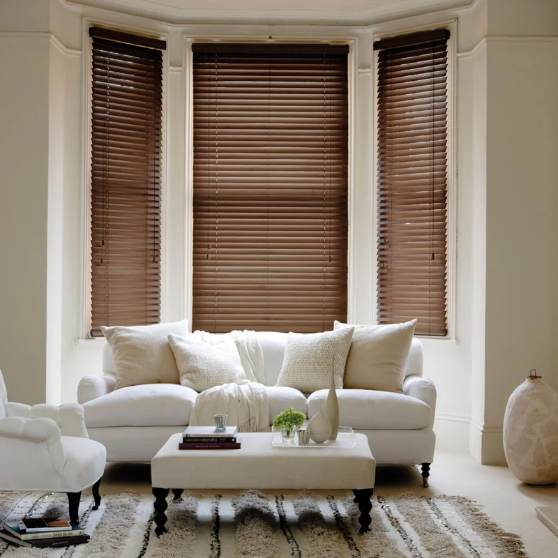 Living room bay window with dark wooden blinds.