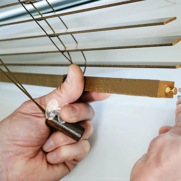 Hand attaching a hold-down bracket to wooden blinds