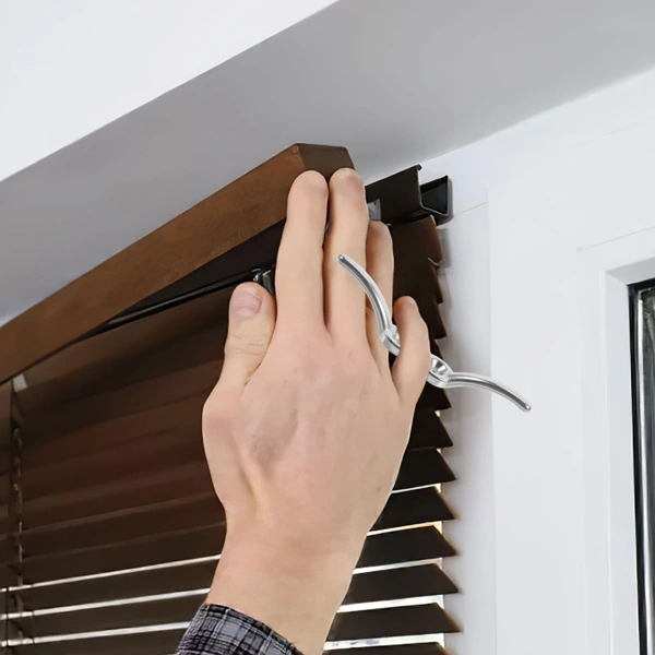 Hand installing wooden blinds on a bracket